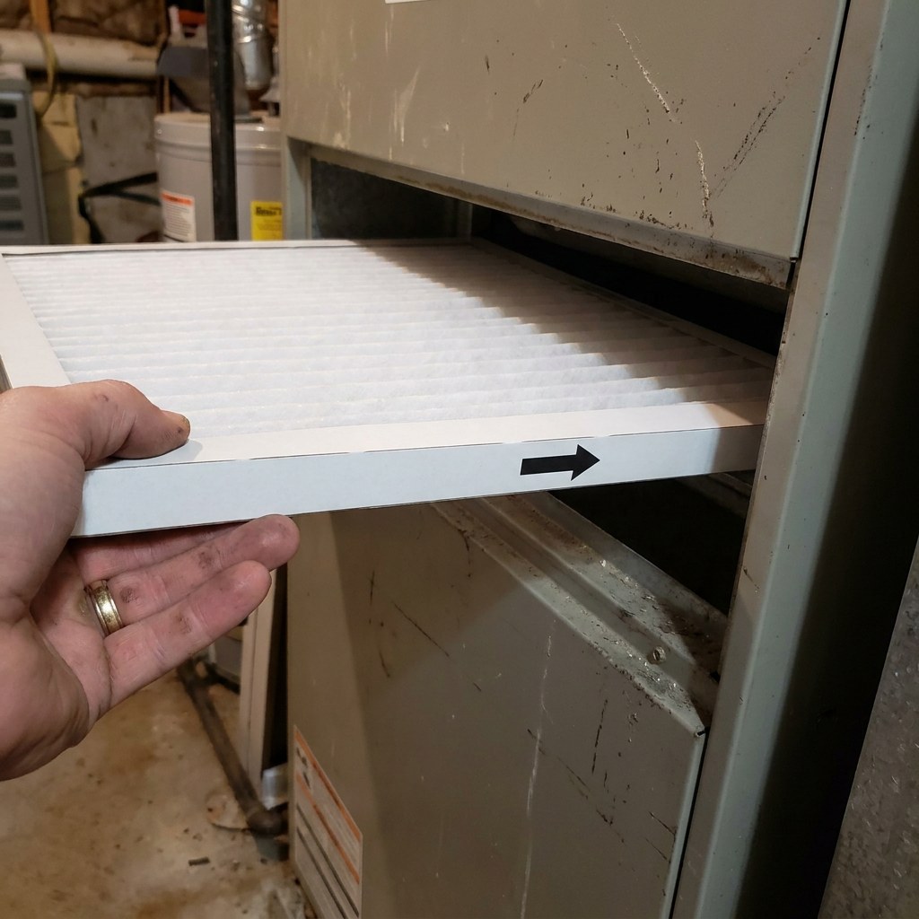 Hand installing new hvac air filter